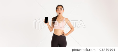 Sport, technology and active lifestyle concept. Amazed and impressed asian sportswoman, athlete say wow look thrilled and showing mobile phone fitness application, workout tracker app 93819594