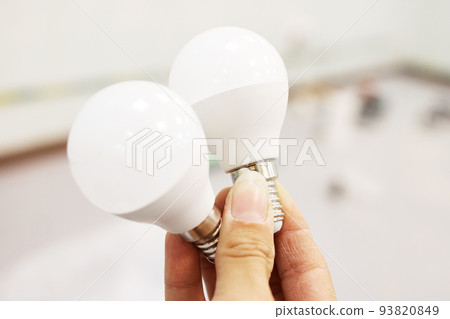 Glowing light bulb in hand in the dark 93820849