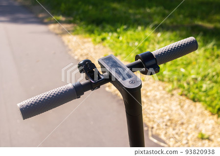 Electric scooter steering wheel on a green forest background Electric scooter steering wheel on a green forest background 93820938