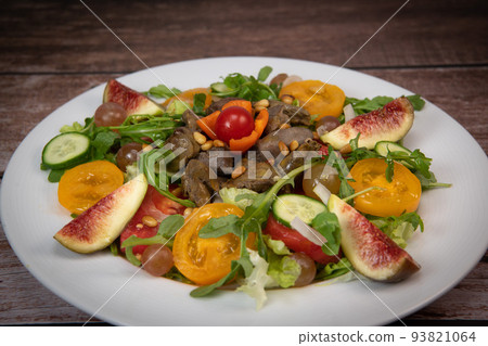 Recipe for fried chicken liver and gizzards with salad and tomatoes, cucumber, figs, grapes on a 93821064