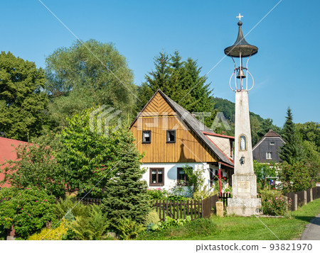 Machovska Lhota, Czechia. Small historical bell tower and typical wooden house 93821970