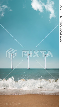 Carbon Neutral and ESG Concepts. Carbon Emission, Clean Energy, Wind Energy. Sustainable Resources, Environmental Care. Sand Beach and Wave on Sunny Day with Blurred Wind Turbine in background. Carbon Neutral and ESG Concepts. Carbon Emission, Clean Energy, Wind Energy. Sustainable Resources, Environmental Care. Sand Beach and Wave on Sunny Day with Blurred Wind Turbine in background. 93827725
