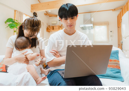 A man opening a laptop in the living room A man opening a laptop in the living room 93829043