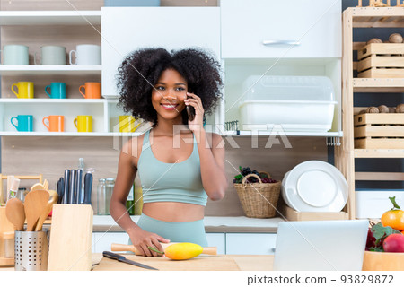 woman using the mobile or smart phone in kitchen at home 93829872