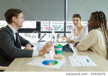 Diverse colleagues gather in brainstorm discuss statistics together. Diverse colleagues gather in brainstorm discuss statistics together. 93830070