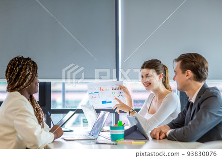 Diverse colleagues gather in brainstorm discuss statistics together. Diverse colleagues gather in brainstorm discuss statistics together. 93830076