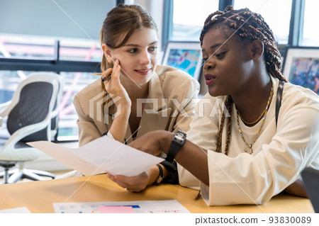Diverse colleagues gather in brainstorm discuss statistics together.  93830089