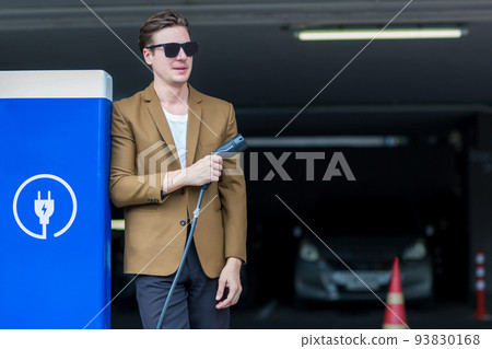 Man hand holding Electric car charger.  Man hand holding Electric car charger.  93830168