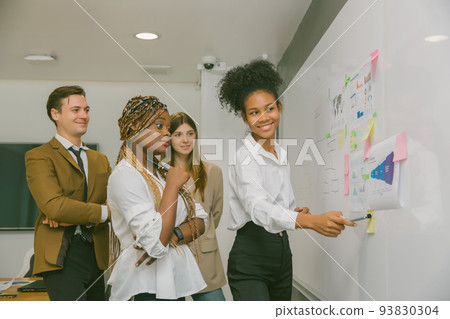 Diverse colleagues gather in brainstorm discuss statistics together. Diverse colleagues gather in brainstorm discuss statistics together. 93830304