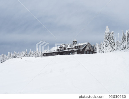 winter landscape with Mountain hut Vosecka Bouda and snowy spruce tree forest with snow covered conifers. Krkonose Mountains, Czech Republic, cloudy day. 93830680