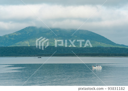 sea bay with foggy mountains in the background, view of the Mendeleev volcano on a cloudy day sea bay with foggy mountains in the background, view of the Mendeleev volcano on a cloudy day 93831182