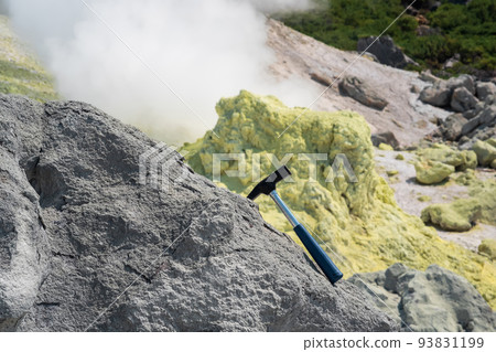 geological hammer in the rock against the backdrop of an steaming fumarole on the slope of a volcano geological hammer in the rock against the backdrop of an steaming fumarole on the slope of a volcano 93831199