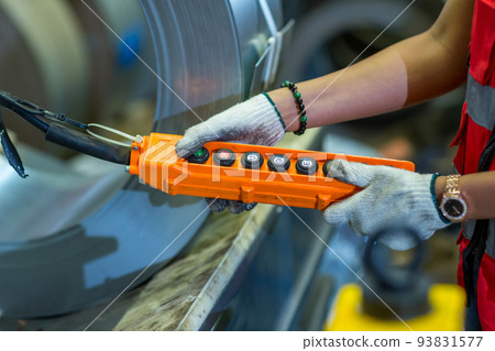 Hand using remote control overhead cranes remote.  93831577