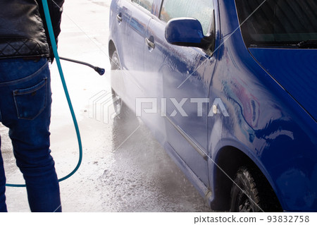 A man washing a car at a car wash A man washing a car at a car wash 93832758
