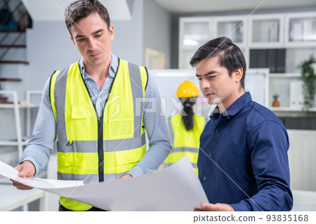 Competent investor investor discuss and brainstorm with engineers on blueprint. Competent investor investor discuss and brainstorm with engineers on blueprint. 93835168