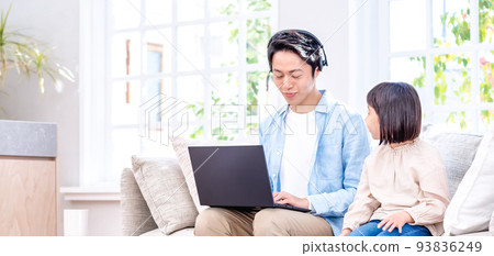 一個孩子坐在沙發上和一個在筆記本電腦上工作的爸爸交談 93836249