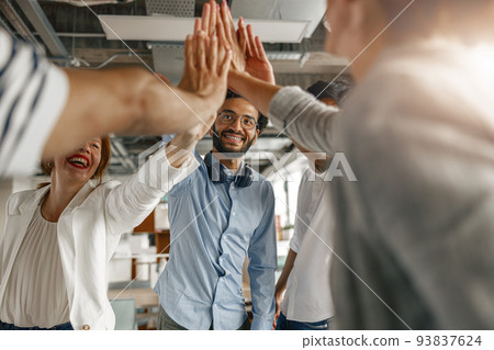Happy group of multi ethnic coworkers stacked hands together as concept of corporate unity 93837624