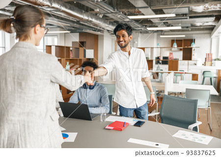 Smiling female boss leader shaking hand of new team member recruiting him for job on staff briefin 93837625
