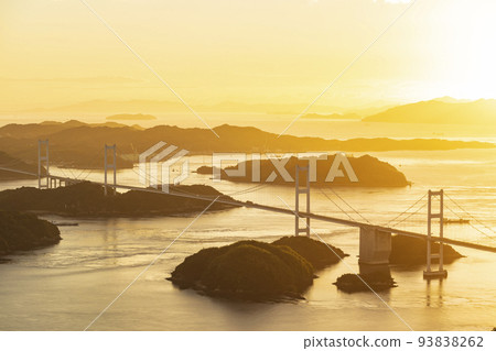 View of Shimanami Kaido and Kurushima Kaikyo Bridge at sunset seen from Mt. Kiro Observatory Park on Oshima, Seto Inland Sea, Ehime Prefecture 93838262
