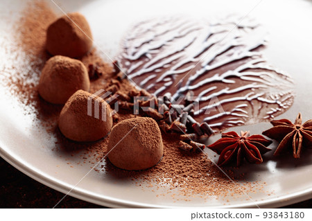 Chocolate truffles on a beige plate with chocolate sauce. Chocolate truffles on a beige plate with chocolate sauce. 93843180