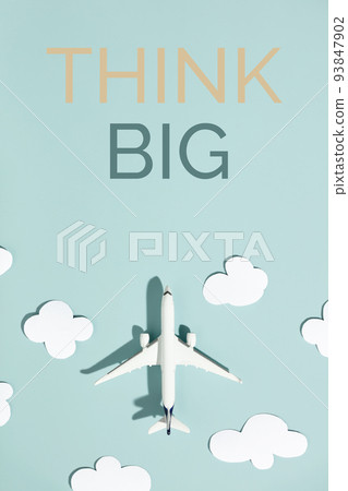Motivation quote Think big Miniature toy airplane and paper clouds on colorful background 93847902