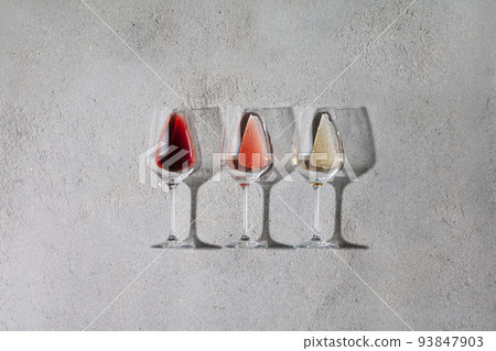 Flat-lay of red, rose and white wine in glasses on grey stone background Flat-lay of red, rose and white wine in glasses on grey stone background 93847903