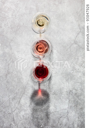 Flat-lay of red, rose and white wine in glasses on grey stone background 93847926