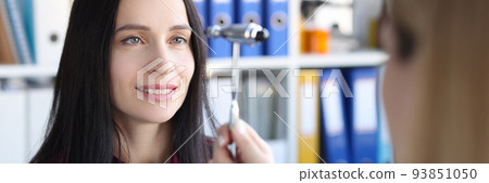 Neurologist driving hammer in front of patient eyes in clinic Neurologist driving hammer in front of patient eyes in clinic 93851050
