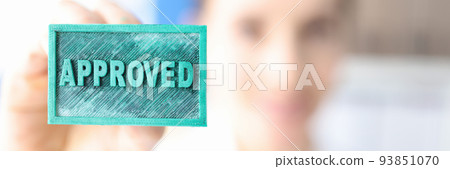 Woman holding green ink stamp approved closeup Woman holding green ink stamp approved closeup 93851070