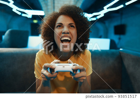 A young woman plays on a console.The emotion of victory, excitement and joy. A young woman plays on a console.The emotion of victory, excitement and joy. 93851517