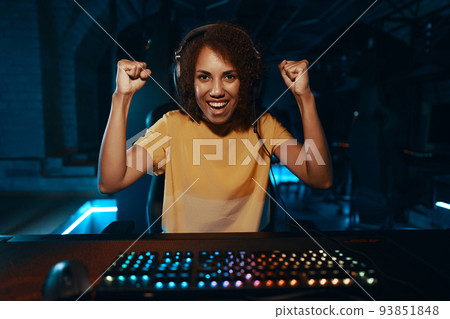 Portrait of a young woman in headphones who won a computer game. The emotion of joy for the first place. Portrait of a young woman in headphones who won a computer game. The emotion of joy for the first place. 93851848