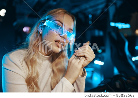 Cute blonde in futuristic fashion style. Neon glasses for a young woman. 93852562