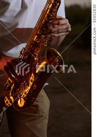Hands and saxophone close up. The guy plays a wind instrument 93852830