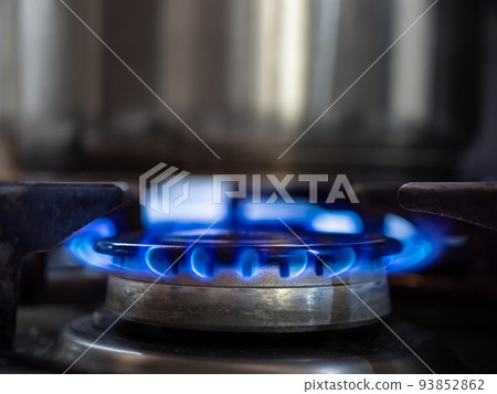 Blue flame in the burner of a kitchen gas stove close-up. 93852862