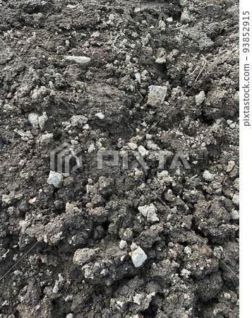 Longitudinal image material of large and small charcoal-colored crushed stones and soil laid as embankment 93852915