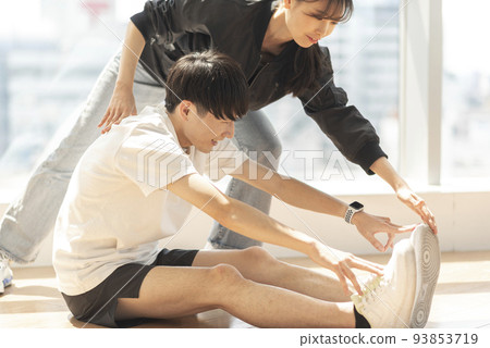 一個身體僵硬的男人正在接受教練的指導 93853719