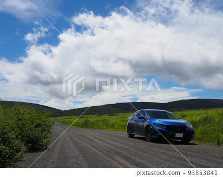 一輛藍色汽車在草地上的碎石路上行駛 一輛藍色汽車在草地上的碎石路上行駛 93853841