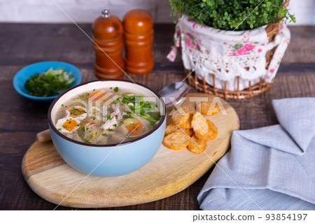Soup with chicken, noodles, potatoes, quail eggs and carrots. Seasoned with onions and parsley. Close-up. Soup with chicken, noodles, potatoes, quail eggs and carrots. Seasoned with onions and parsley. Close-up. 93854197