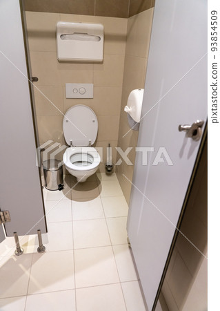 Classic toilet cubicle with open door in a public restroom 93854509