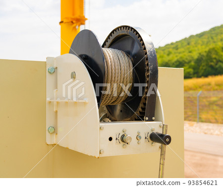 Close-up shot of a mechanical winch with a steel cable 93854621