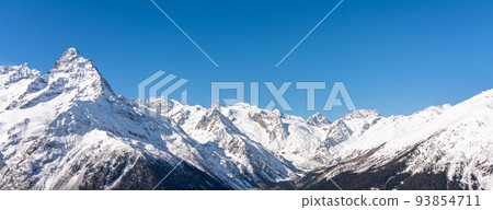 Panoramic view of winter snowy mountains in Caucasus region in Russia with blue sky 93854711