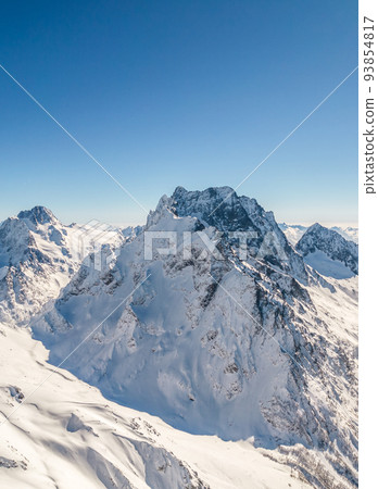 Mountain peak covered with snow under a clear sky  93854817