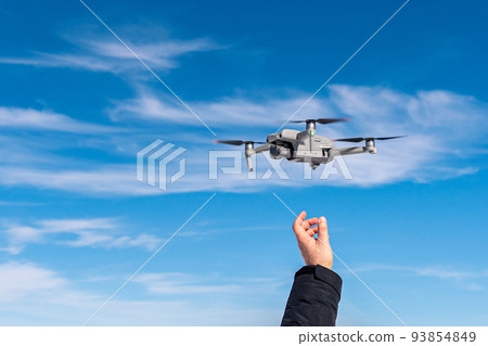 Drone taking off from male hand against blue sky background Drone taking off from male hand against blue sky background 93854849
