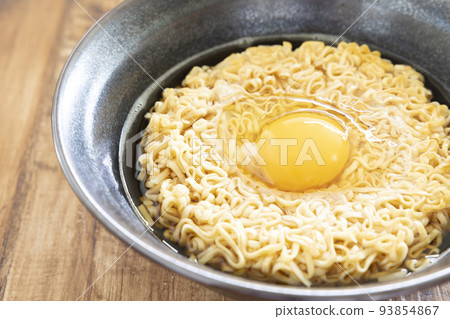 Delicious instant ramen topped with a raw egg 93854867