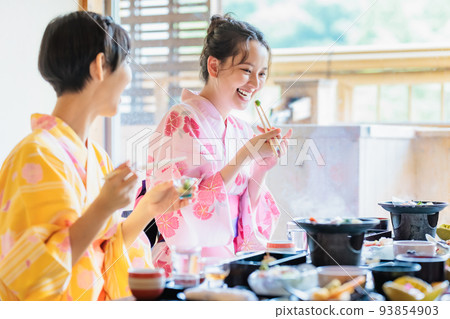 A young woman eating in a yukata at a hot spring inn, a girls' trip 93854903