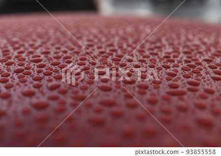 Closeup wet red car paint surface with hydrophobic ceramic coating 93855558