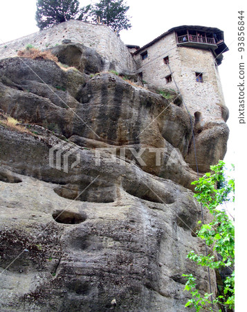 Panoramic view of the Holy Trinity Monastery of Meteora in Greece high in the mountains. Unusual architecture. Panoramic view of the Holy Trinity Monastery of Meteora in Greece high in the mountains. Unusual architecture. 93856844