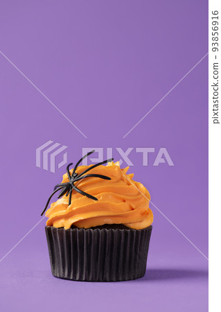 Halloween cupcake with pumpkin buttercream and spider decoration. Halloween muffin. Halloween creative food. 93856916