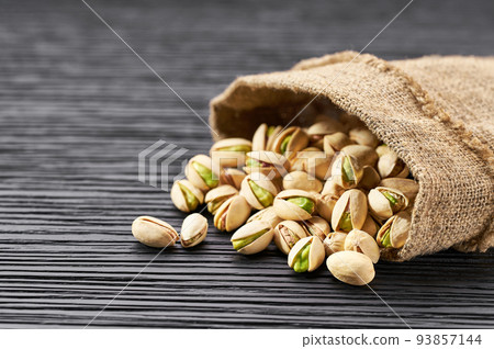 Pistachios in bag on black table with copy space. Pistachios in bag on black table with copy space. 93857144