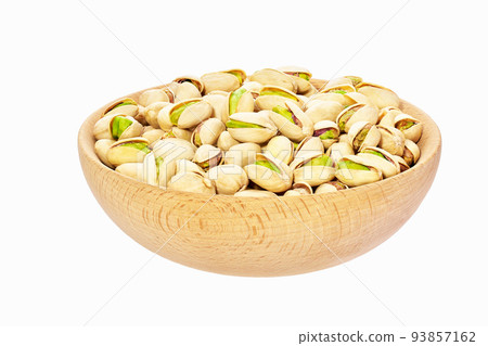 Pistachios nuts in wooden bowl isolated on white background. 93857162
